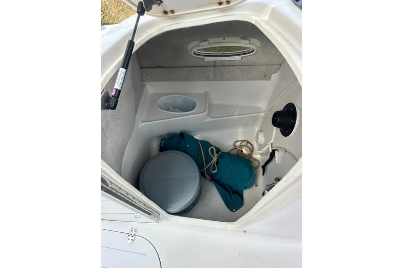 Slide: The Image of 2004 Vectra S-215 boat storage compartment with gear and rope inside. - 11