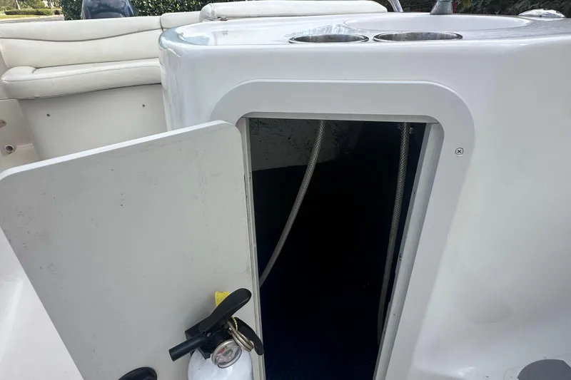 Slide: The Image of Open storage compartment on a 2004 Vectra S-215 boat with visible fire extinguisher. - 12