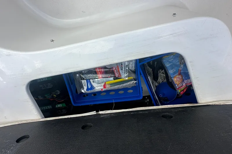 Slide: The Image of Storage compartment in a 2004 Vectra S-215 boat with various items and supplies. - 13
