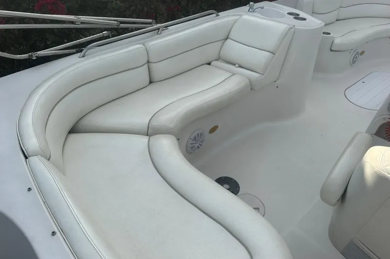 Slide: The Image of Luxurious white seating on 2004 Vectra S-215 boat, featuring curved design and cup holders. - 16