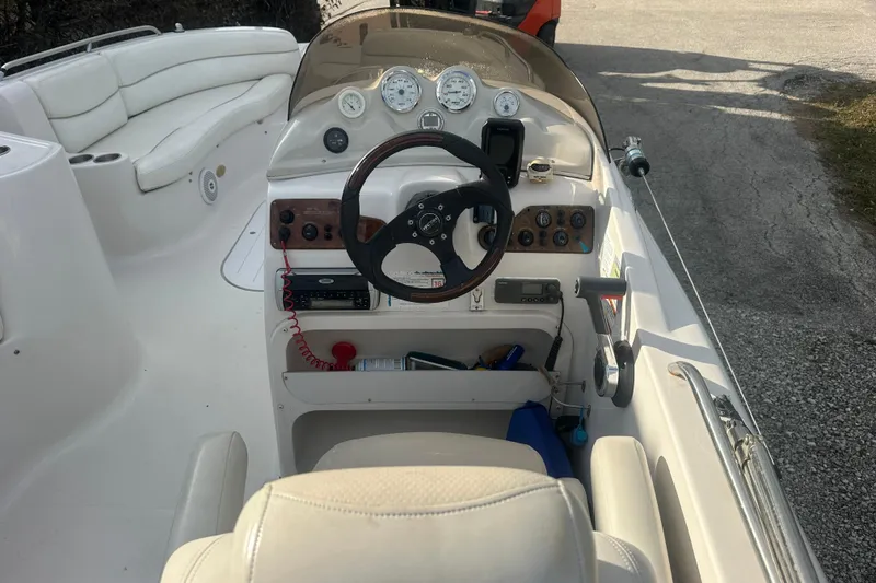 Slide: The Image of 2004 Vectra S-215 boat cockpit with steering wheel, gauges, and white seating. - 9