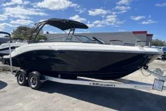 Slide: The Image of 2024 Sea Ray SPX 230 boat on trailer under blue sky. - 2