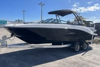 Slide: The Image of 2024 Sea Ray SPX 230 boat on trailer, sleek black design under clear blue sky. - 5