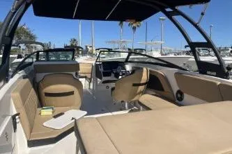 Slide: The Image of 2024 Sea Ray SPX 230 boat interior with beige seating and modern dashboard. - 7