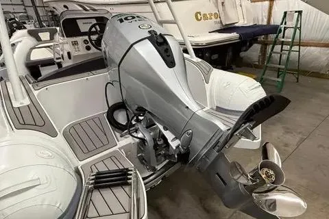 Slide: The Image of 2024 Highfield Sport 520 boat with powerful outboard motor in a storage facility. - 3