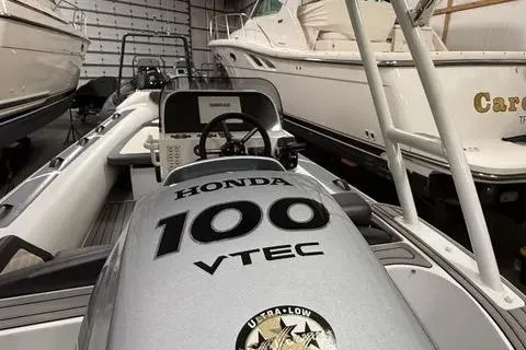 Slide: The Image of 2024 Highfield Sport 520 boat with Honda 100 VTEC engine in a storage facility. - 4