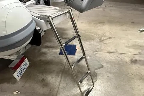 Slide: The Image of 2024 Highfield Sport 520 boat with a foldable ladder in a garage setting. - 5