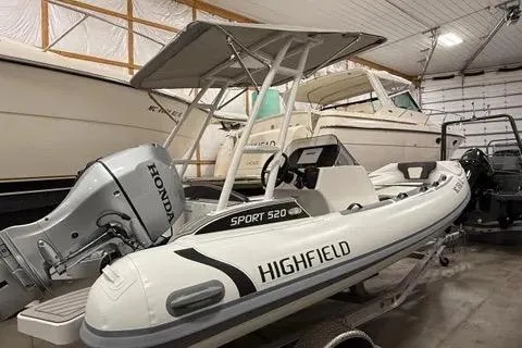 Slide: The Image of 2024 Highfield Sport 520 boat with Honda engine in a storage facility. - 9