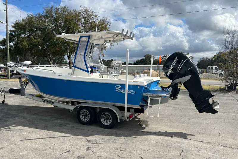 Slide: The Image of 2011 Renegade OF 23 boat on trailer with Mercury outboard motor, parked outdoors. - 10