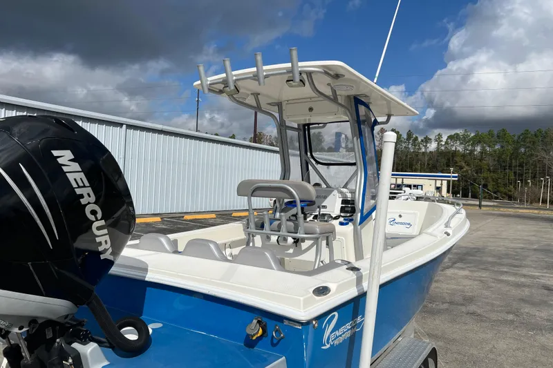 Slide: The Image of 2011 Renegade OF 23 boat with Mercury engine, parked outdoors under cloudy sky. - 13
