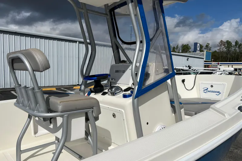 Slide: The Image of 2011 Renegade OF 23 boat interior with seating and control panel, under cloudy sky. - 15