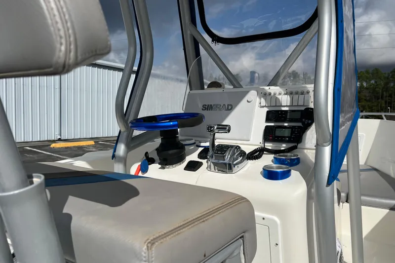 Slide: The Image of 2011 Renegade OF 23 boat cockpit with Simrad navigation system and blue steering wheel. - 17