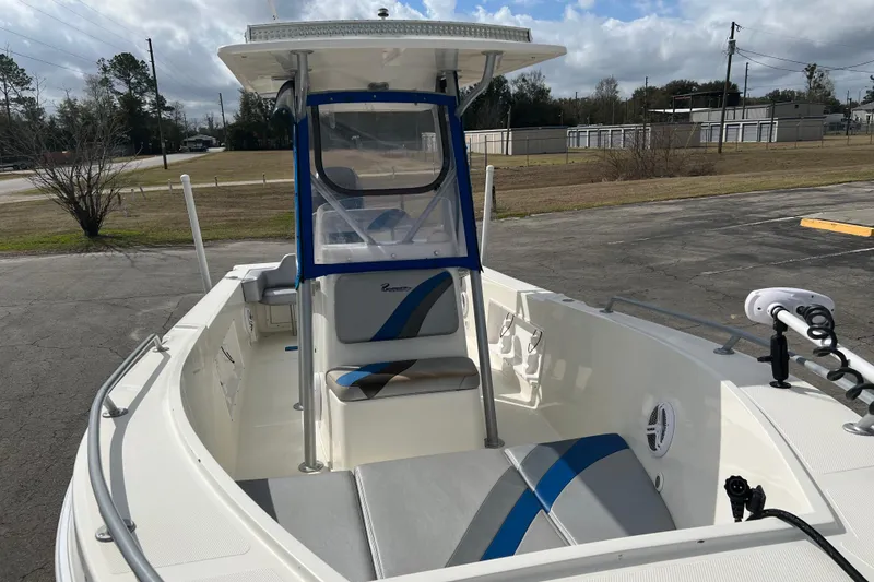 Slide: The Image of 2011 Renegade OF 23 boat with blue and gray seating, parked outdoors. - 18