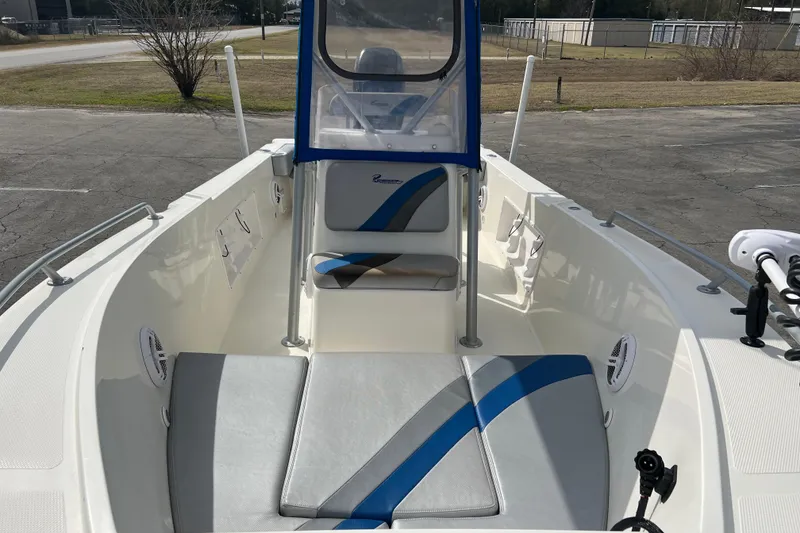 Slide: The Image of 2011 Renegade OF 23 boat interior with blue and gray seating, parked outdoors. - 19