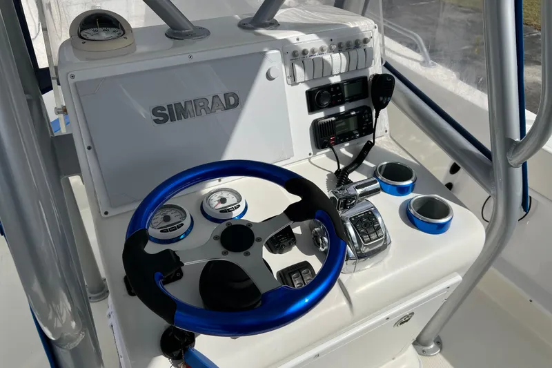 Slide: The Image of Control panel of 2011 Renegade OF 23 boat with Simrad electronics and blue steering wheel. - 21