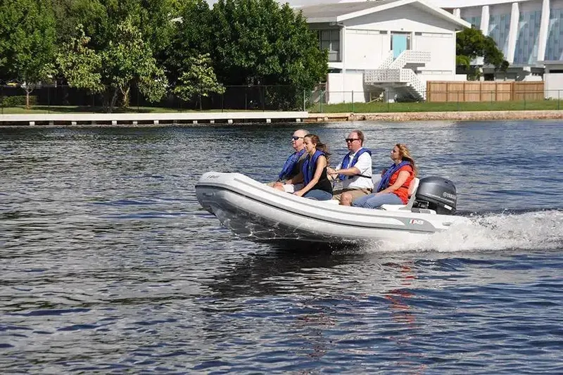 Slide: The Image of 2026 AB Inflatables Mares 12 VSX boat cruising on a calm waterway with four passengers. - 5
