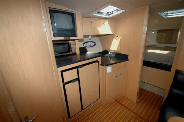 Slide: The Image of Interior of 2002 Tiara Yachts 3500 Open with kitchenette and sleeping area. - 10