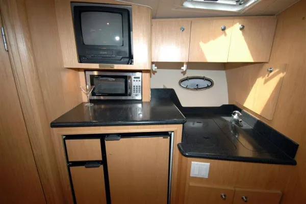 Slide: The Image of Tiara Yachts 3500 Open 2002 kitchen area with TV and microwave. - 11