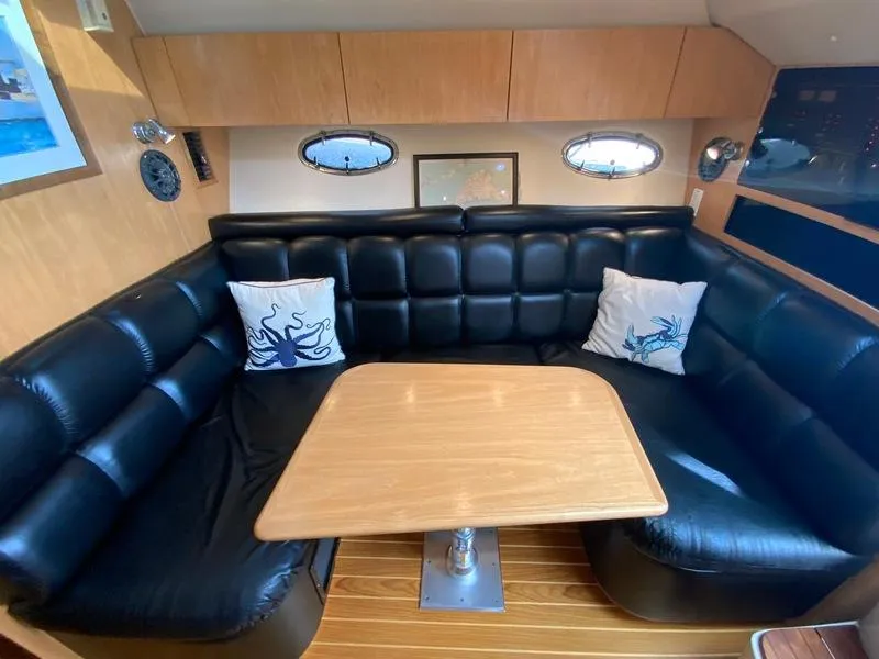 Slide: The Image of Interior of 2002 Tiara Yachts 3500 Open with leather sofa and wooden table. - 14