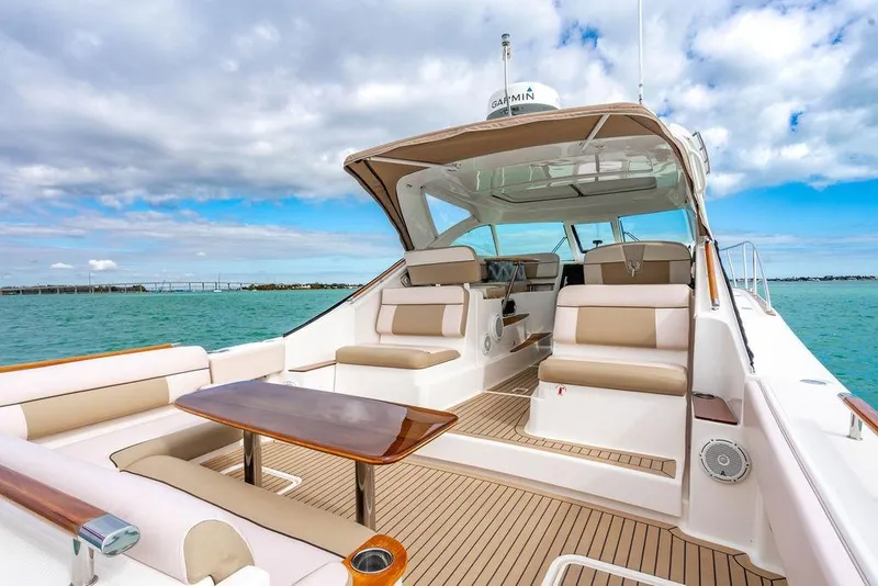Slide: The Image of 2013 Tiara Yachts 3600 Coronet, luxury boat interior with seating and table on open water. - 12