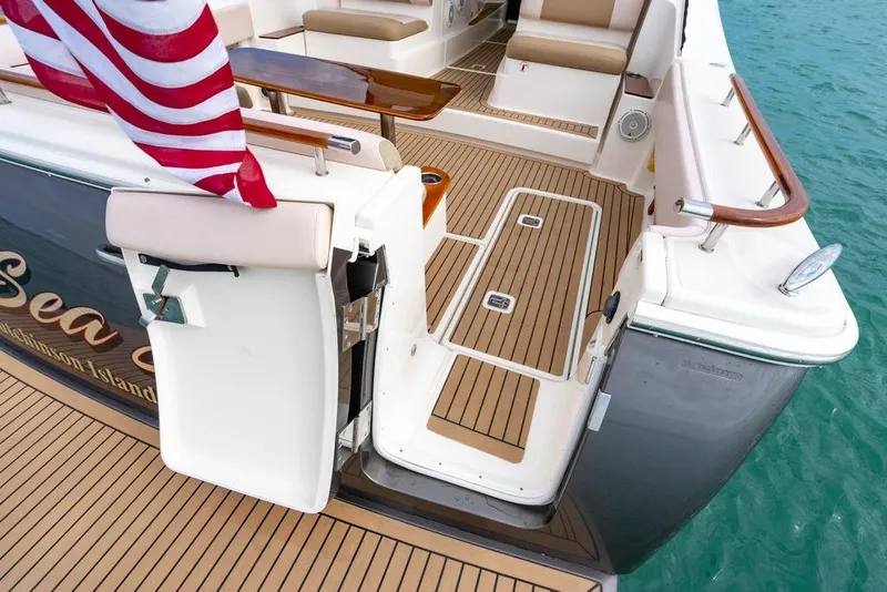 Slide: The Image of 2013 Tiara Yachts 3600 Coronet deck with American flag, teak flooring, and seating. - 13