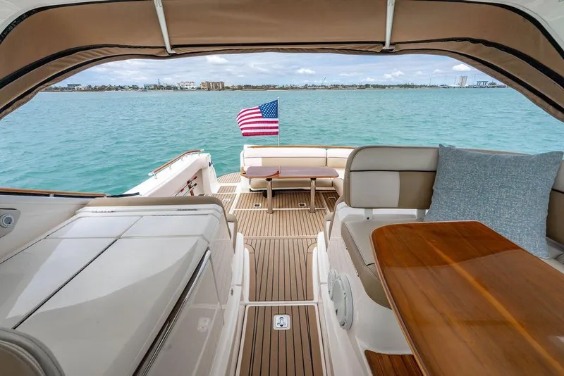 Slide: The Image of 2013 Tiara Yachts 3600 Coronet interior with American flag, ocean view, and seating area. - 15