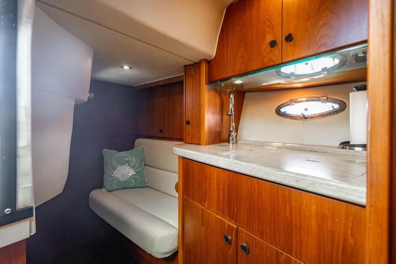 Slide: The Image of 2013 Tiara Yachts 3600 Coronet interior with wooden cabinetry and cozy seating area. - 4