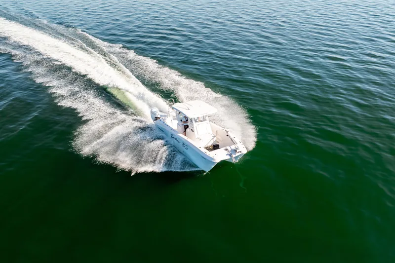 Slide: The Image of 2023 Twin Vee 260 GFX CC boat cruising on open water, creating a wake. - 13
