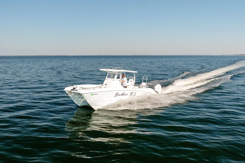 Slide: The Image of 2023 Twin Vee 260 GFX CC boat cruising on open water under clear skies. - 15