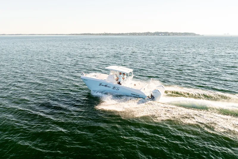 Slide: The Image of 2023 Twin Vee 260 GFX CC cruising on open water under clear skies. - 23