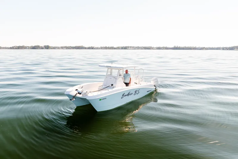 Slide: The Image of 2023 Twin Vee 260 GFX CC boat on calm water with a person onboard. - 3