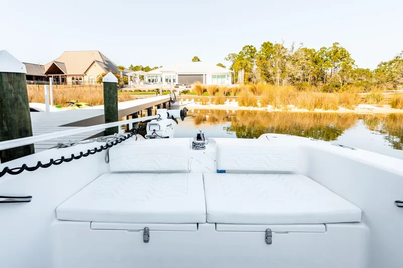 Slide: The Image of 2023 Twin Vee 260 GFX CC boat docked by serene waterfront with lush greenery. - 30