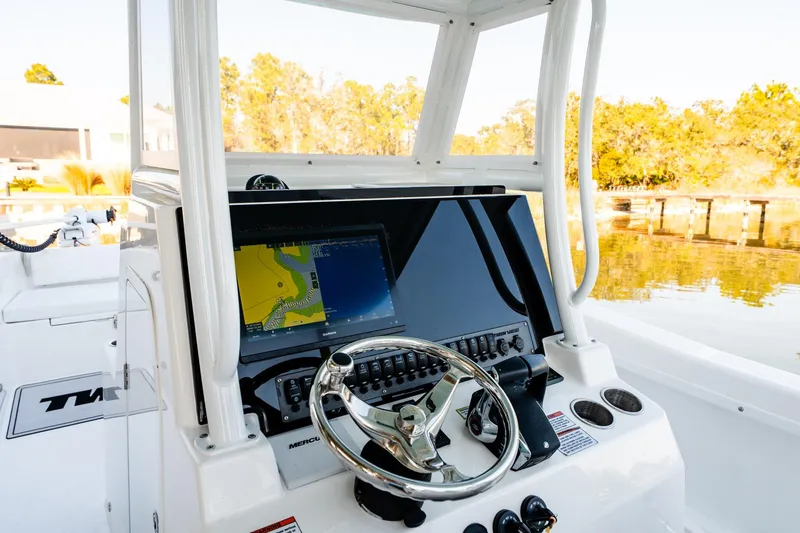 Slide: The Image of 2023 Twin Vee 260 GFX CC boat dashboard with navigation display and steering wheel. - 37
