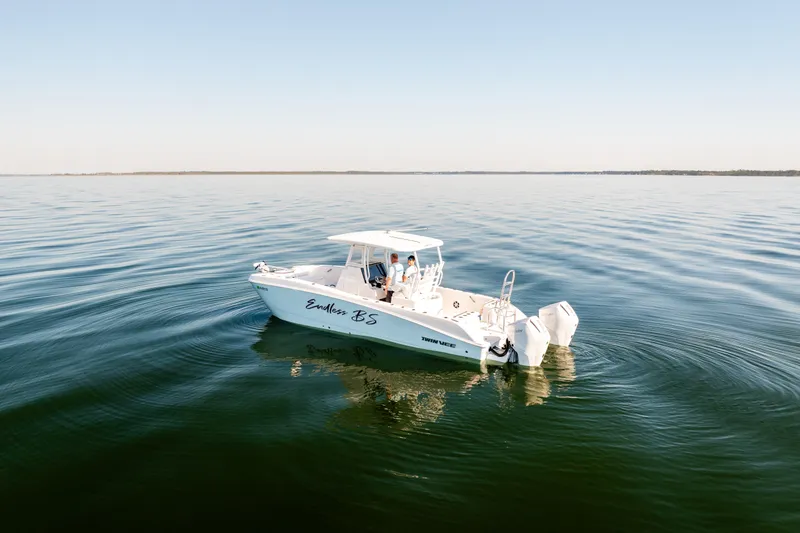 Slide: The Image of 2023 Twin Vee 260 GFX CC boat cruising on calm waters under clear sky. - 4