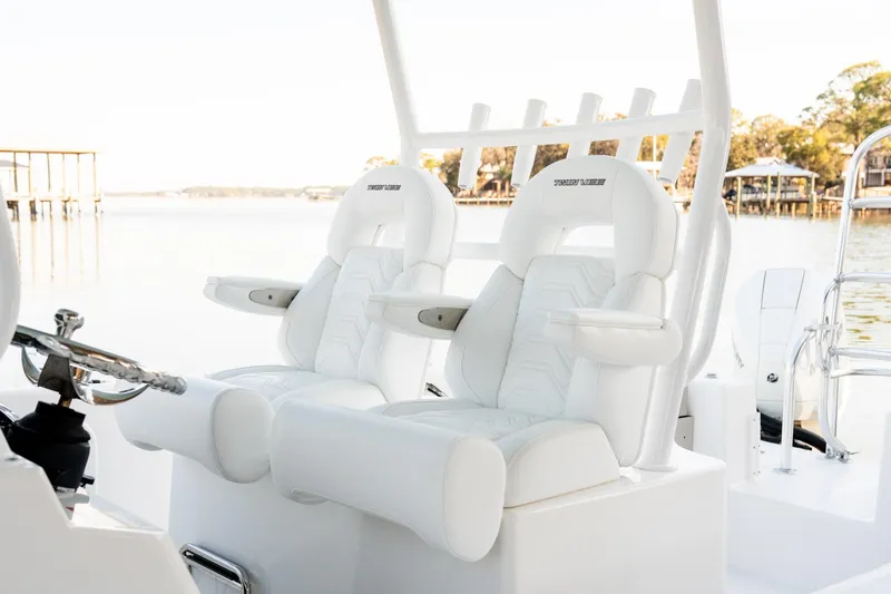 Slide: The Image of 2023 Twin Vee 260 GFX CC boat with luxurious white seating and scenic waterfront view. - 48