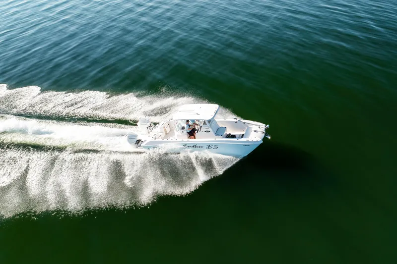 Slide: The Image of 2023 Twin Vee 260 GFX CC boat cruising on open water, creating a dynamic wake. - 8