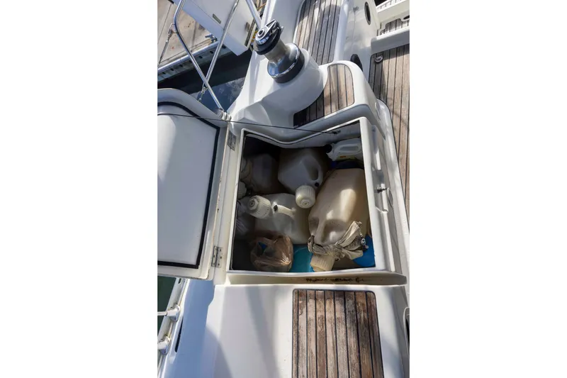 Slide: The Image of Storage compartment on 2001 Jeanneau Sun Odyssey 43 DS sailboat, filled with plastic containers. - 16