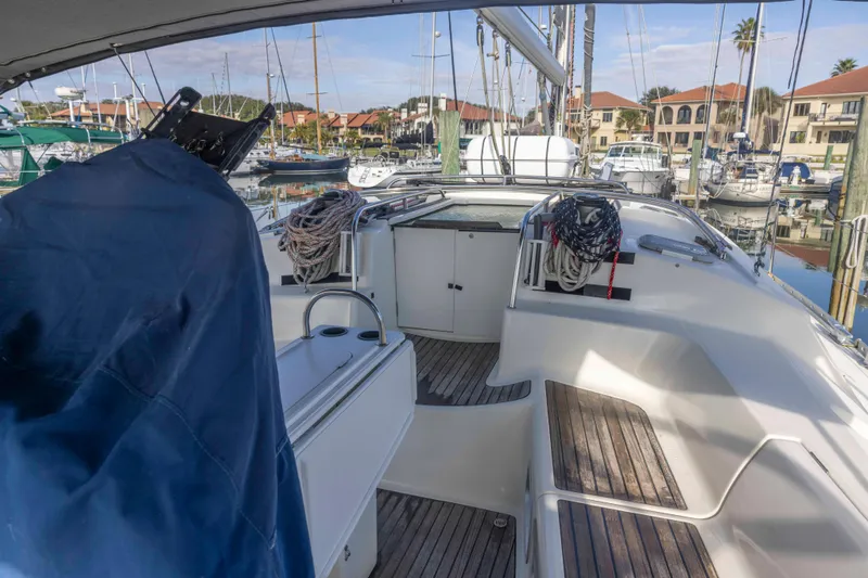 Slide: The Image of 2001 Jeanneau Sun Odyssey 43 DS sailboat cockpit with marina view, featuring wooden seating and rigging. - 20
