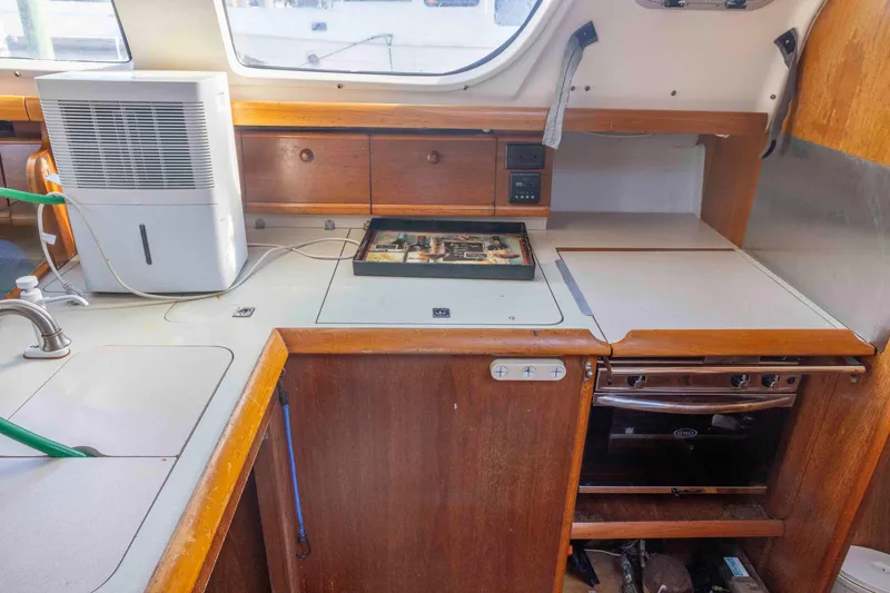 Slide: The Image of Interior of 2001 Jeanneau Sun Odyssey 43 DS yacht kitchen with appliances and wooden cabinetry. - 23