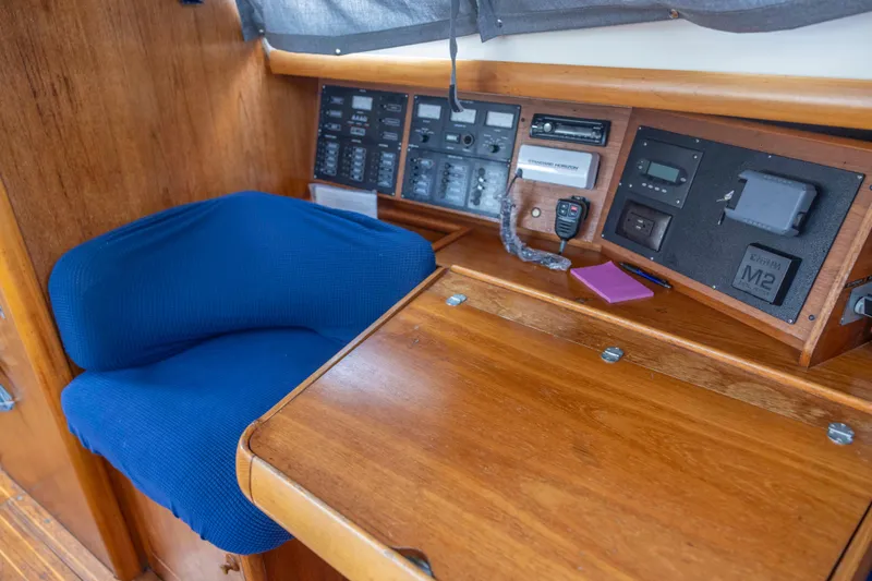 Slide: The Image of Navigation station of 2001 Jeanneau Sun Odyssey 43 DS with blue seat and control panels. - 26