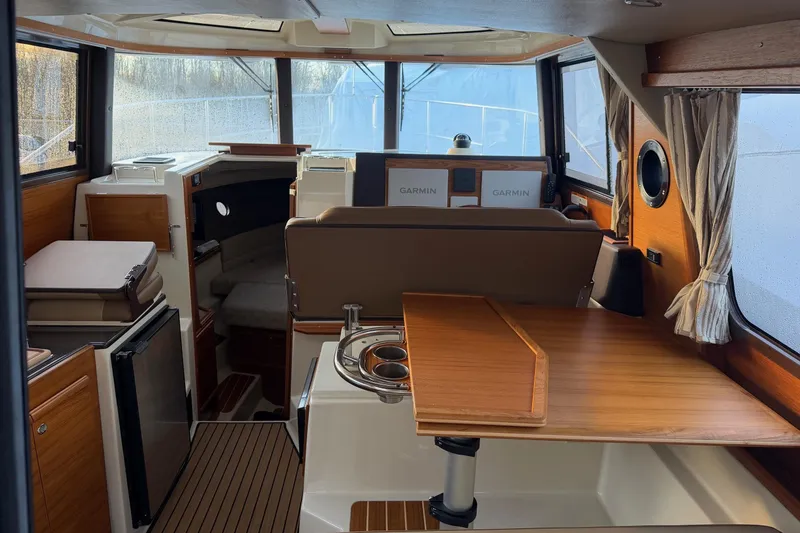 Slide: The Image of 2024 Ranger Tugs R-29 CB interior with wood accents and modern navigation equipment. - 11