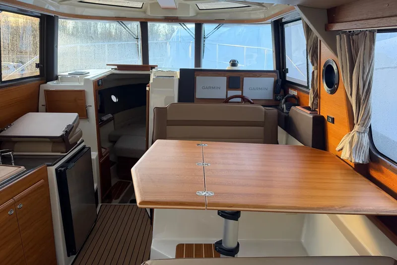 Slide: The Image of 2024 Ranger Tugs R-29 CB interior with wood finishes and Garmin navigation displays. - 12