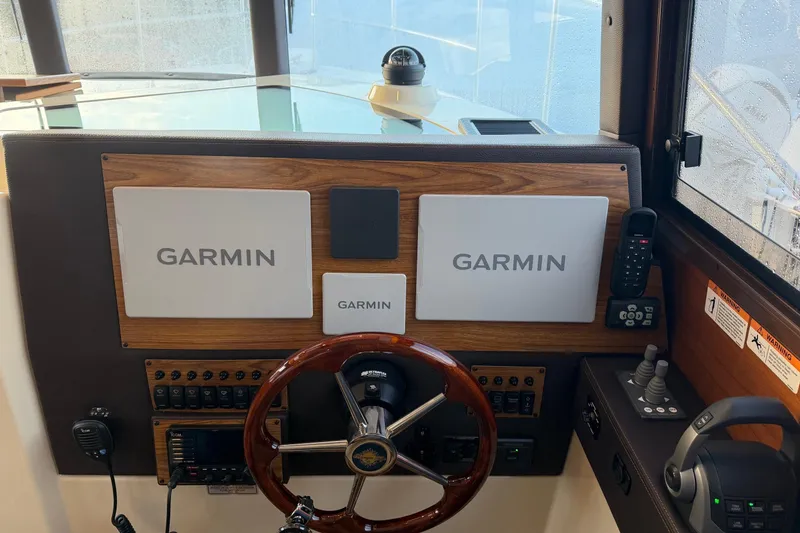 Slide: The Image of 2024 Ranger Tugs R-29 CB helm with Garmin navigation displays and controls. - 13