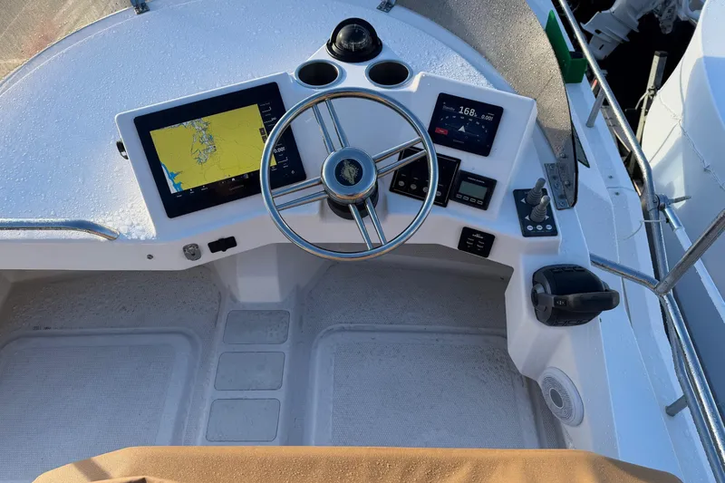 Slide: The Image of 2024 Ranger Tugs R-29 CB helm with navigation screens and steering wheel. - 7