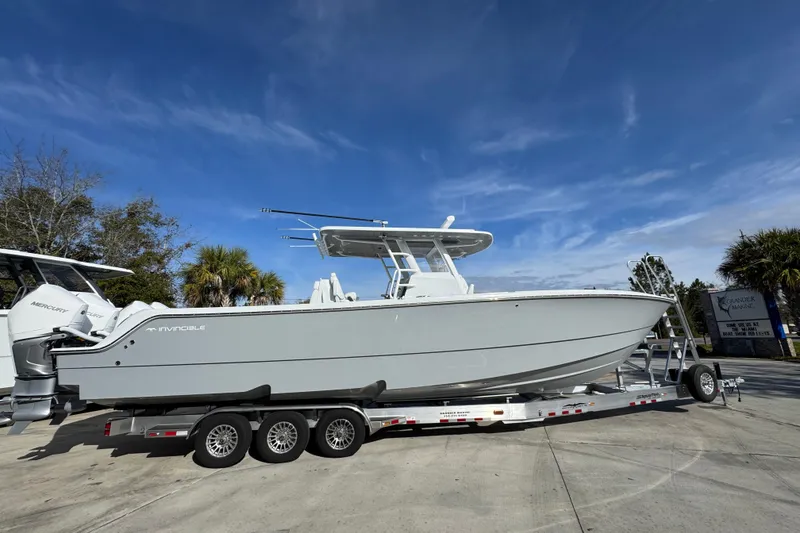 Slide: The Image of 2026 Invincible 36 Catamaran on trailer under clear blue sky. - 10
