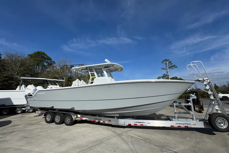 Slide: The Image of 2026 Invincible 36 Catamaran on trailer under clear blue sky. - 11