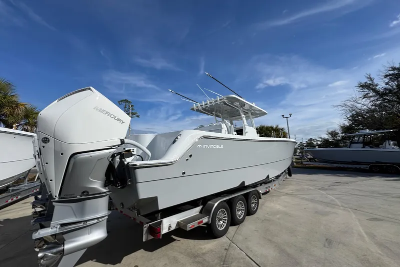 Slide: The Image of 2026 Invincible 36 Catamaran with Mercury engines on a trailer under a clear blue sky. - 13