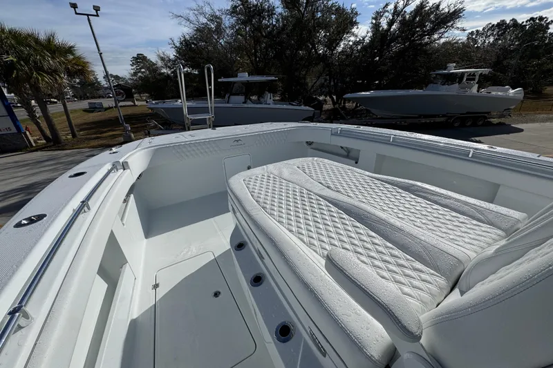 Slide: The Image of 2026 Invincible 36 Catamaran with white cushioned seating, docked outdoors. - 23