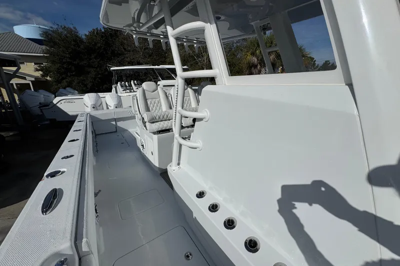 Slide: The Image of 2026 Invincible 36 Catamaran interior with seating and rod holders, docked outdoors. - 25