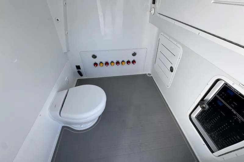 Slide: The Image of Interior of 2026 Invincible 36 Catamaran featuring a compact marine toilet and control panel. - 26
